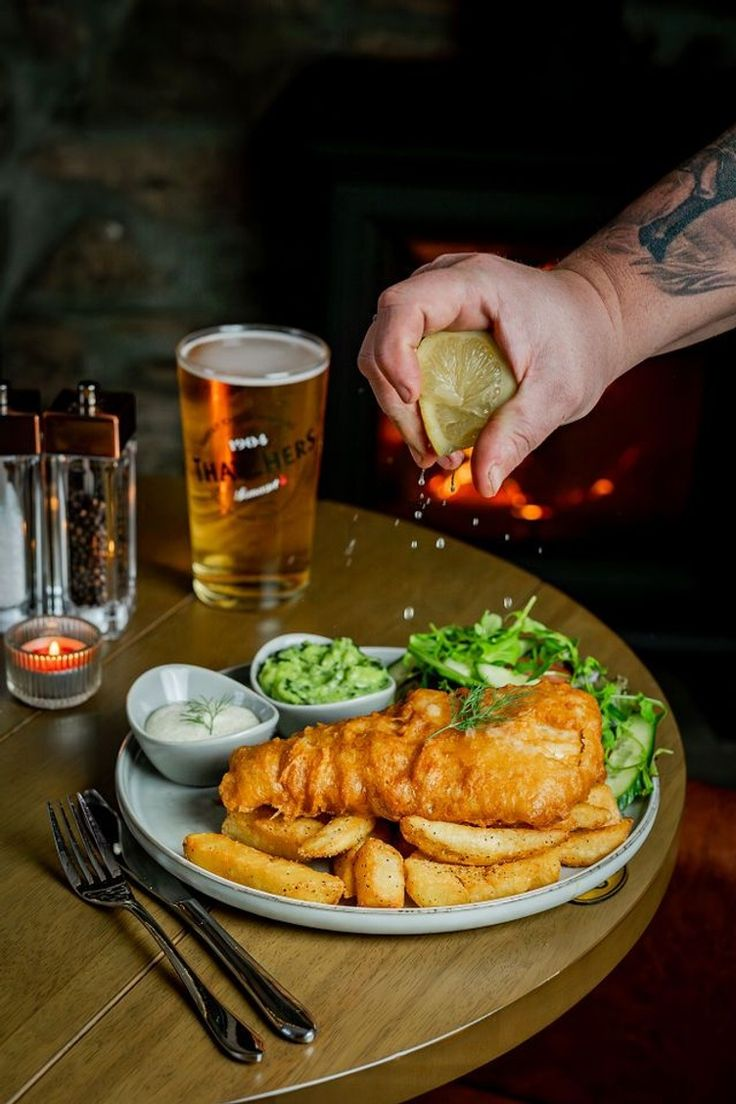 Lemon squeezed over fish and chips with peas and tartar sauce